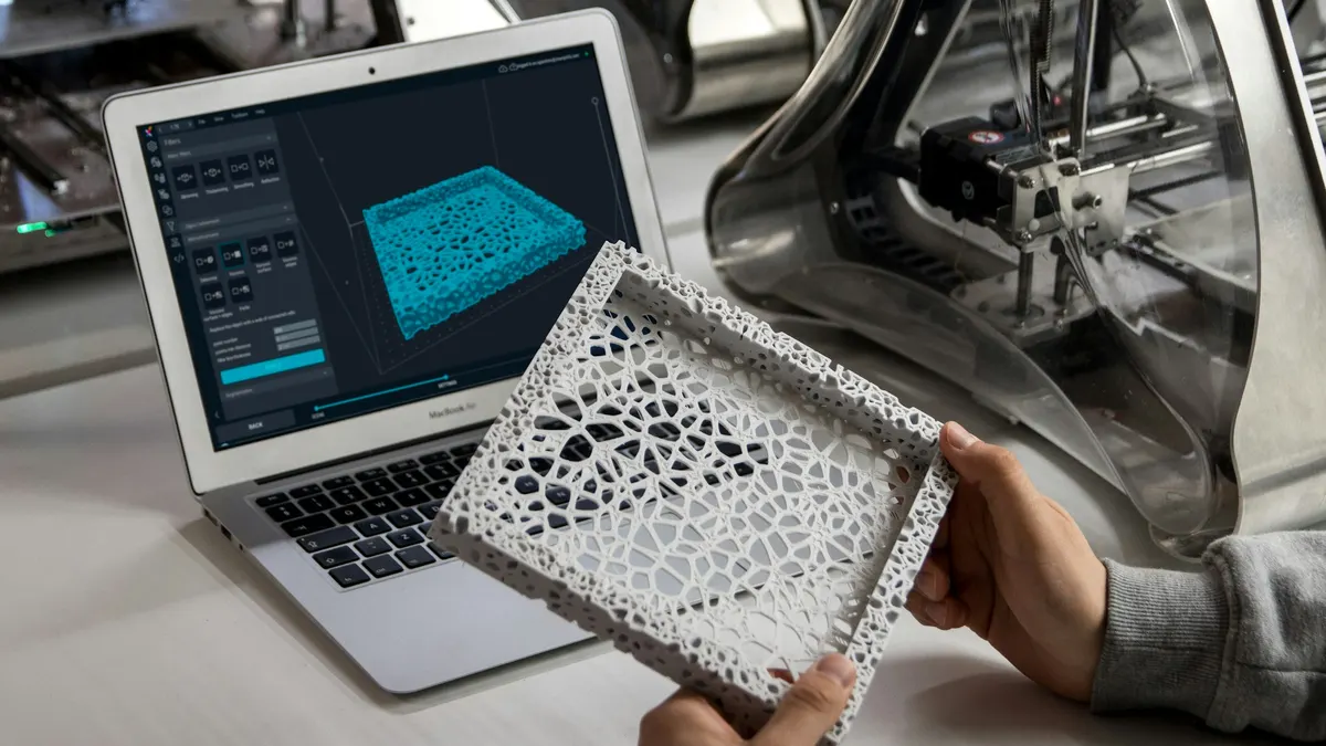Slicer software on a laptop next to a lattice-patterned 3D-printed part